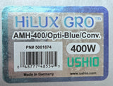A close-up of a HILUX GRO AMH-400 Opti-Blue/Conv. 400W UShiO optical fiber box being held by a hand, with a blurry indoor background.