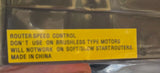 A person holding a packaged industrial electronic component in their lap. The product is wrapped in clear plastic with a prominent yellow warning label that reads 'ROUTERSPEED CONTROL DON'T USE ON BRUSHLESS TYPE MOTORS WILL NOTWORK ON SOFTSTART STARTROUTERS MADE IN CHINA'.