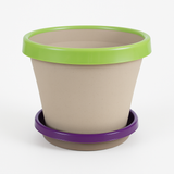 Beige planter with green rim and purple base on a white background